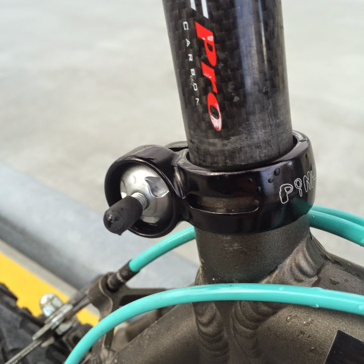 A carbon fiber seatpost secured by a Pinhead locking seatpost skewer.